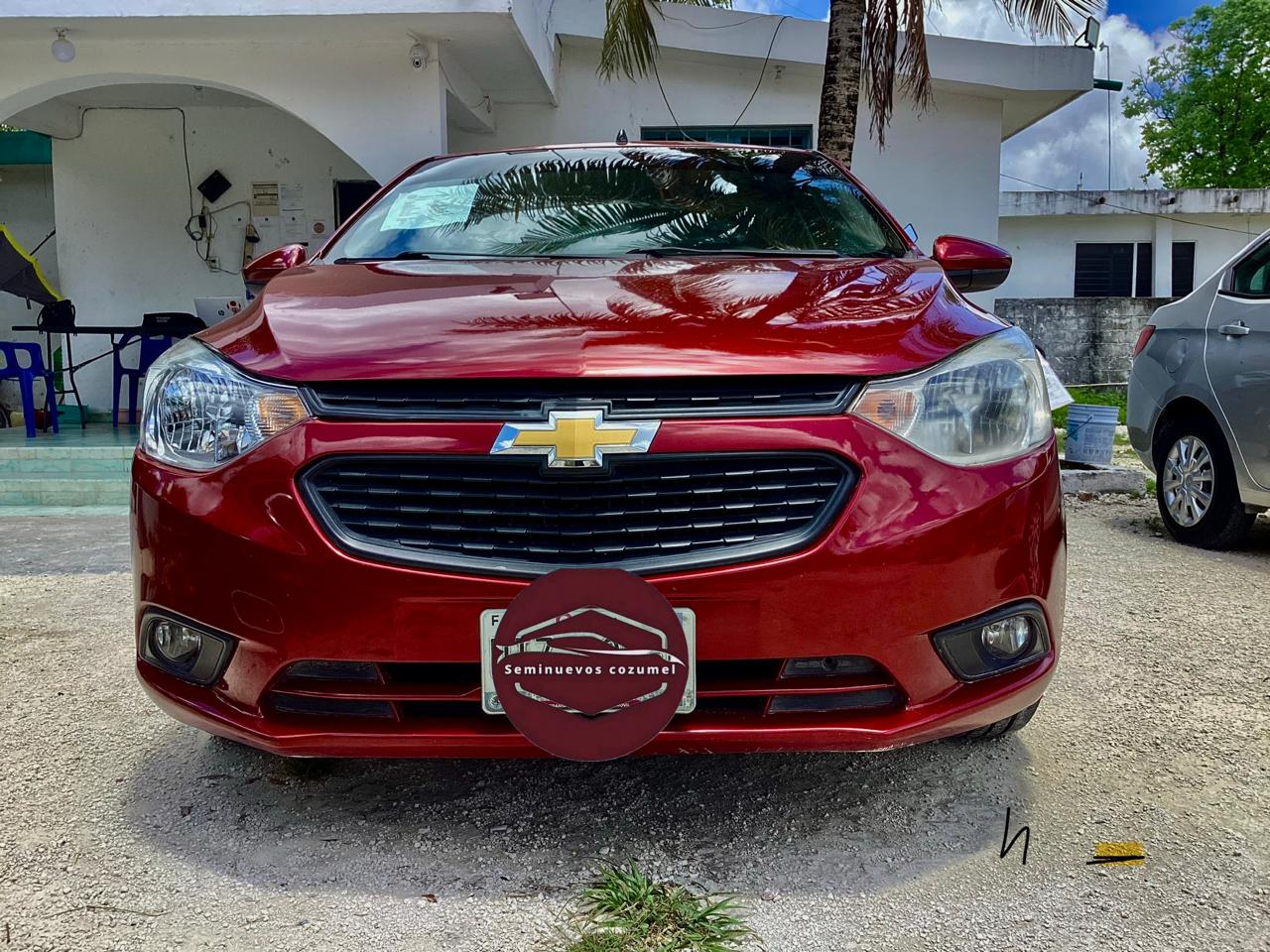Sedan Chevrolet rojo en lote de seminuevos